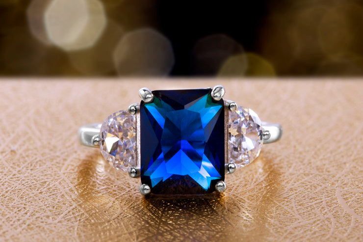 Radiant Cut Simulated Blue Sapphire and Half Moon Cubic Zirconia Ring in Rhodium Plated Silver